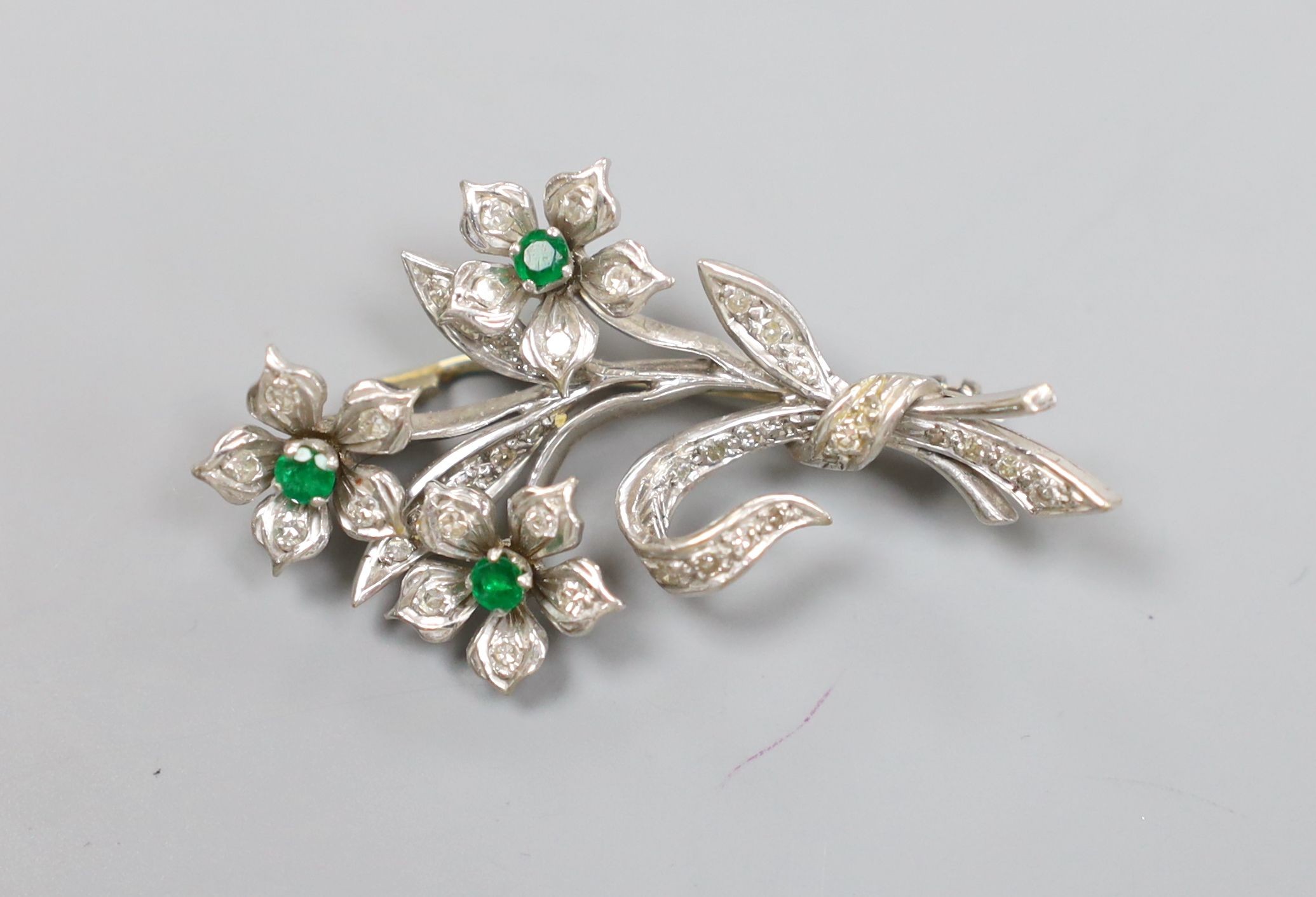 A 20th century white metal, emerald and diamond set spray brooch, 45mm, gross 10 grams.